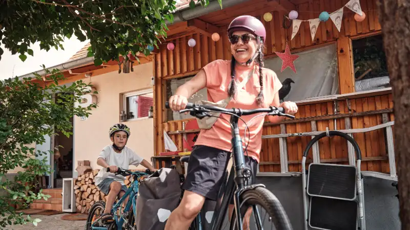 Frau und Kind fahren mit Follow-Me Kupplung zuhause los Frau und Kind fahren mit Follow-Me Kupplung zuhause los