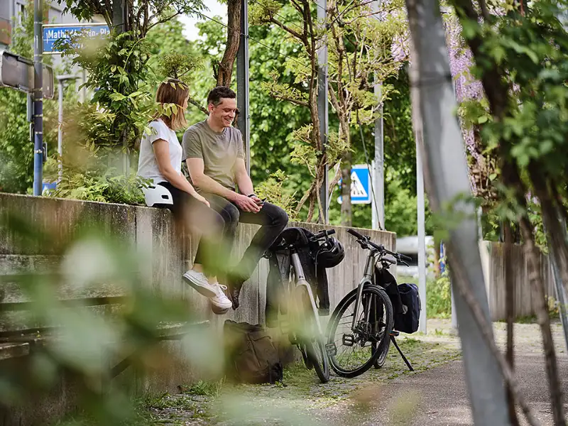 Zwei Radlerinnen sitzen auf der Mauer grüne Stadt